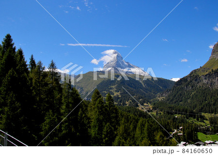 上空の筋雲が印象的なマッターホルン 緑の山麓と木々と共に 上空の筋雲が印象的なマッターホルン 緑の山麓と木々と共に 84160650