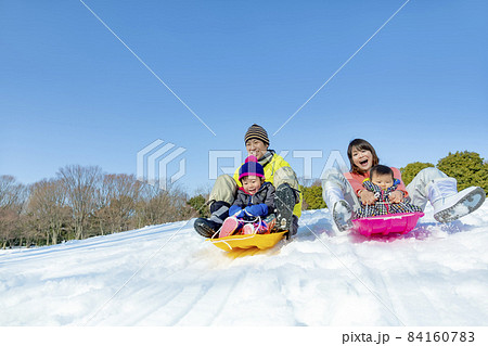 雪の公園で遊ぶ4人家族 84160783