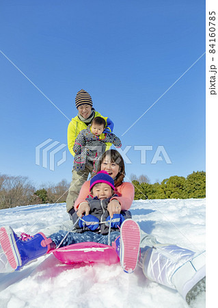 雪の公園で遊ぶ4人家族 84160785