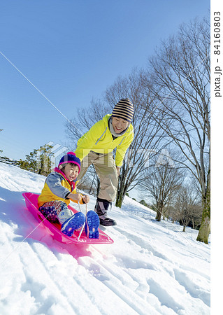 雪の公園で遊ぶ父親と息子 84160803