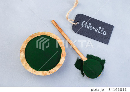 Chlorella superfood in powder, on gray background, horizontal, top view 84161011