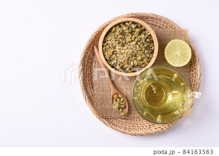 Chamomile tea in a cup glass with dried chamomile flowers, Healthy herbal tea Chamomile tea in a cup glass with dried chamomile flowers, Healthy herbal tea 84163563