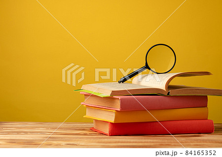 Pile of colorful textbooks on wooden desk 84165352