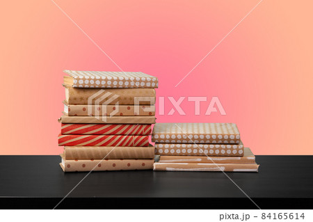 Education concept with stack of books on a table against colored background. Education concept with stack of books on a table against colored background. 84165614
