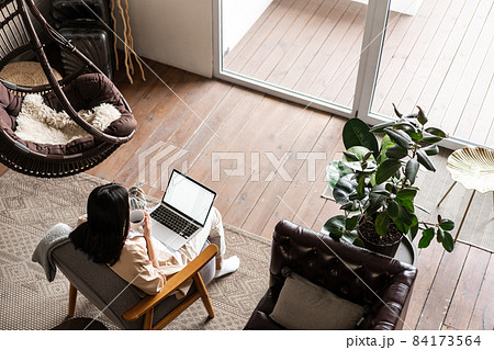 Asian woman working from home on laptop, studying or doing homework on computer, freelancer on remote Asian woman working from home on laptop, studying or doing homework on computer, freelancer on remote 84173564