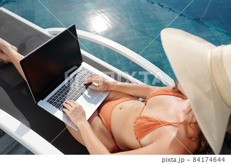 Woman in Bikini Coding on Laptop 84174644