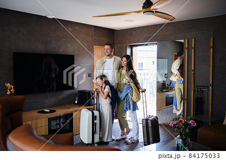 Happy young family with two children enetring room at luxury hotel, summer holiday. 84175033