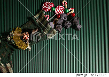 Befana sock with sweet coal and candy on dark greeen background. Italian Epiphany day tradition. 84175377