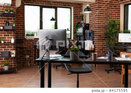Empty startup office with computer and supplies on desk Empty startup office with computer and supplies on desk 84175595