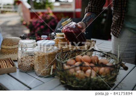 Close up of man buying organic juice outdoors at local farmers market. 84175894