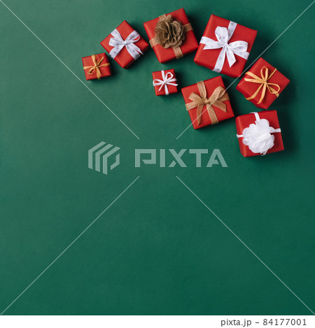 Gift boxes with white and brown bows on a green backdrop. 84177001