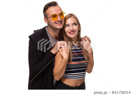 Happy young lovely couple standing together and laughing. Studio shot over white background. Happy young lovely couple standing together and laughing. Studio shot over white background. 84178054