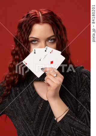 Beautiful redheaded woman is holding some playing cards. Casino Beautiful redheaded woman is holding some playing cards. Casino 84180201