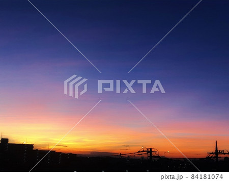 夕暮れの紫とオレンジのグラデーションの空と街並みの風景の写真素材