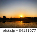 夕暮れのオレンジの空と沈む夕日が見える田舎の田園風景 84181077