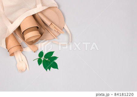 Eco-friendly tableware - kraft paper cups and containers in white cotton bag on light gray background with copy space for text. Street food take away paper packaging - cups, plates, straws Eco-friendly tableware - kraft paper cups and containers in white cotton bag on light gray background with copy space for text. Street food take away paper packaging - cups, plates, straws 84181220