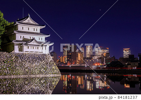 名古屋市　名古屋城の西南隅櫓のライトアップと名古屋駅の高層ビル群の遠景 84181237