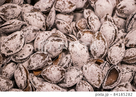 Salted apricot kernels close-up. Selling diet products in the store. 84185282