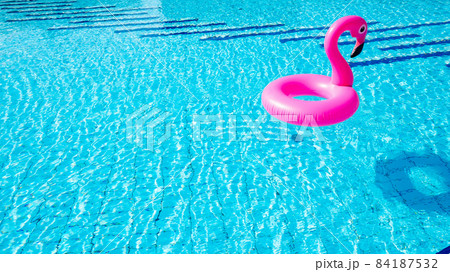 Beach flamingo. Pink inflatable flamingo in water for summer beach background. Pool float party. 84187532