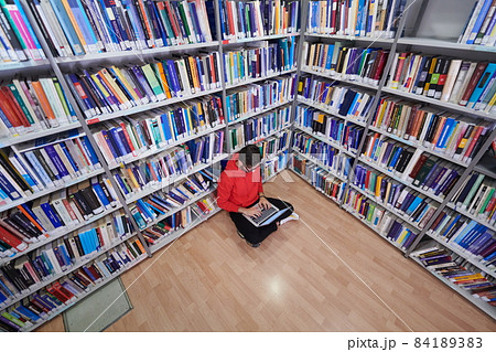 the students uses a notebook, laptop and a school library 84189383