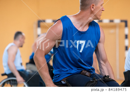 disabled war veterans in action while playing basketball on a basketball court with professional sports equipment for the disabled disabled war veterans in action while playing basketball on a basketball court with professional sports equipment for the disabled 84189475