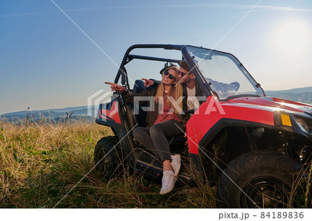 couple enjoying beautiful sunny day while driving a off road buggy couple enjoying beautiful sunny day while driving a off road buggy 84189836