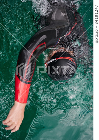 triathlon athlete swimming on lake wearing wetsuit 84191247