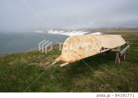 Arctic landscape with a boat on the shores of the Bering Sea. 84191771