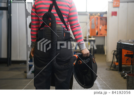 a portrait of a women welder holding a helmet and preparing for a working day in the metal industry a portrait of a women welder holding a helmet and preparing for a working day in the metal industry 84192056