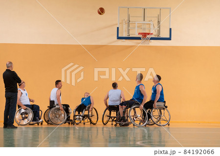 disabled war veterans in action while playing basketball on a basketball court with professional sports equipment for the disabled 84192066
