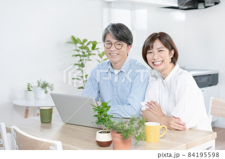 パソコンの前で微笑む父娘 パソコンの前で微笑む父娘 84195598