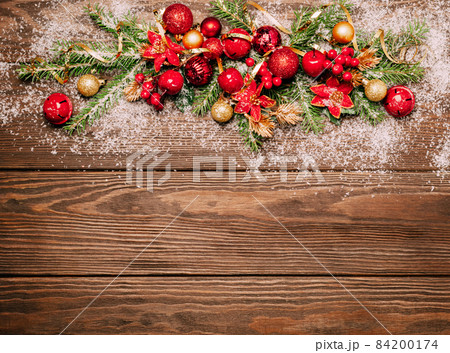 Festive Christmas background red balls green branches spruce serpentine sequins wooden dark background. 84200174