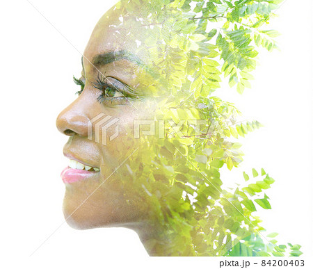 A portrait of an attractive girl combined with foliage. Double exposure. 84200403