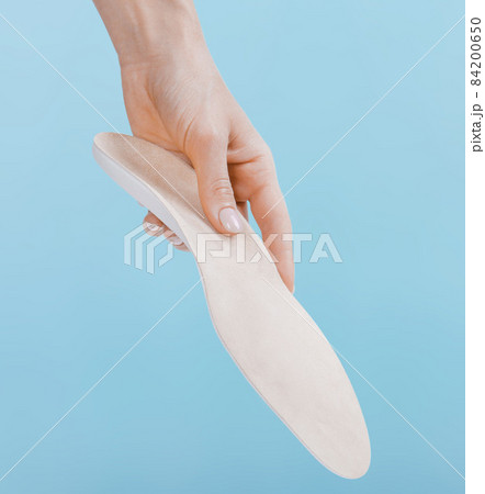 Orthopedic insole isolated on a blue background. Medical insoles. Treatment and prevention of flat feet and foot diseases. Foot care, feet comfort. Wear comfortable shoes. Flat Feet Correction. 84200650