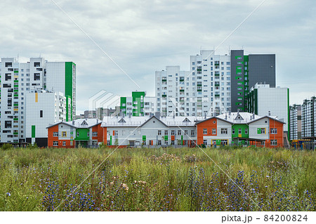Modern construction, new neighborhood. Modern beautiful new buildings. Colored wall on the background of blue sky. 84200824