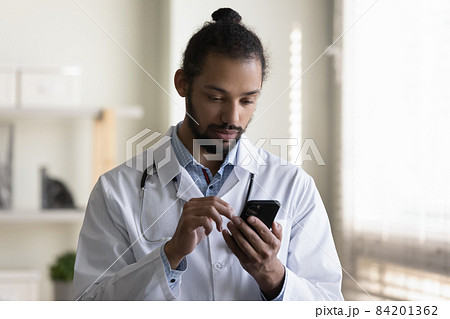 Close up African American man doctor using smartphone in hospital 84201362