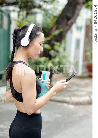 Female Jogger Choosing Music 84201854