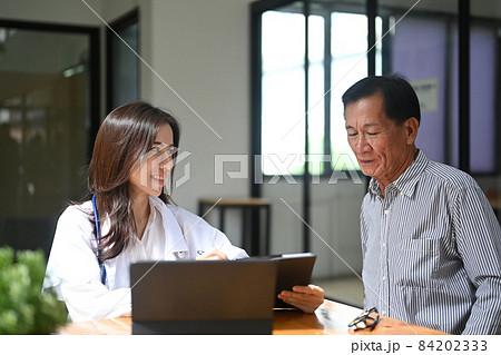 Smiling female doctor in white uniform consultation with senior patient. Smiling female doctor in white uniform consultation with senior patient. 84202333