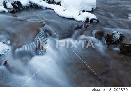 Winter mountain waterfall snow scene. Snowy mountain waterfall landscape. Winter mountain waterfall in Shipot waterfall - Carpathian Mountains, Ukraine. 84202379