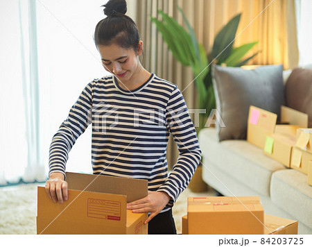 Small business entrepreneur packing package for ready to ship to her customer. Small business entrepreneur packing package for ready to ship to her customer. 84203725
