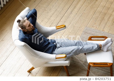 Relaxed young hipster man sleeping in cozy armchair. 84203751