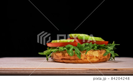 Craft burger is cooking on black background. Consist: sauce, aru Craft burger is cooking on black background. Consist: sauce, aru 84204248