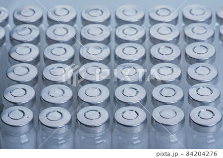 Glass medical ampoule vial for injection. Medicine is dry white drug penicillin powder or liquid with of aqueous solution in ampulla. Close up. Glass medical ampoule vial for injection. Medicine is dry white drug penicillin powder or liquid with of aqueous solution in ampulla. Close up. 84204276