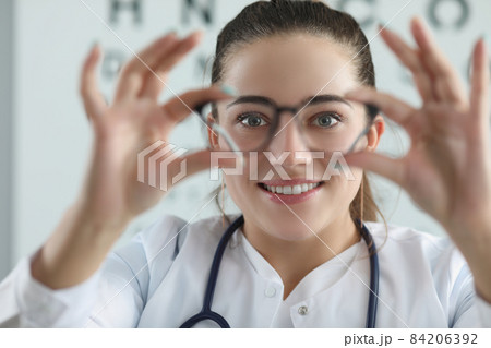 Woman eye doctor with eye test chart on background Woman eye doctor with eye test chart on background 84206392