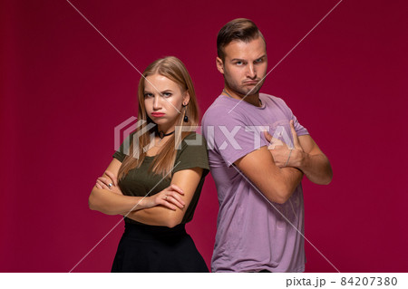 Studio portrait of a young couple in casual wear quarreled and taking a step towards reconciliation. 84207380