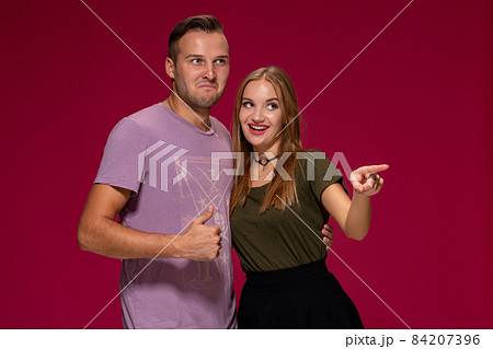 People, friendship, love and leisure concept - lovely couple with thumbs-up gesture on burgundy background 84207396