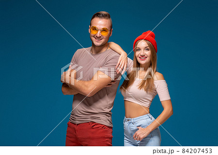 Studio lifestyle portrait of two best friends hipster wearing stylish bright outfits, hats, denim shorts and glasses, going crazy and having great time together. 84207453