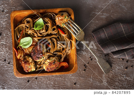 Plate soba with fried cutlets and sauce on a table. 84207895
