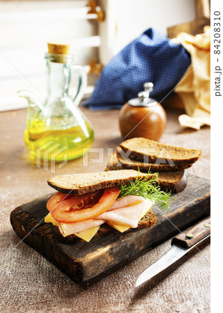 Sandwich with tasty ham on wooden board Sandwich with tasty ham on wooden board 84208310