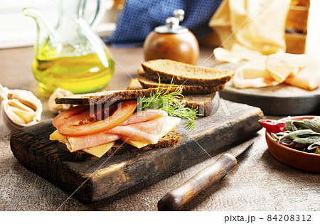 Sandwich with tasty ham on wooden board Sandwich with tasty ham on wooden board 84208312